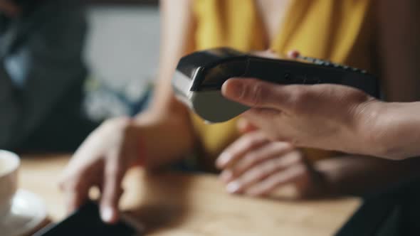 Young Lady Making Online Payment with Smartphone in Cafe Using Modern Device