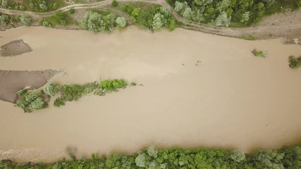 Aerial view of wide dirty river with muddy water in flooding period during heavy rains in spring.