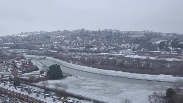 Sideways tracking drone shot of snowy Exeter over the River Exe CROP