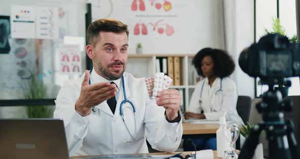 Doctor Holding Packs of Pills in His Hand During Recording Videovlog for Medical Channel