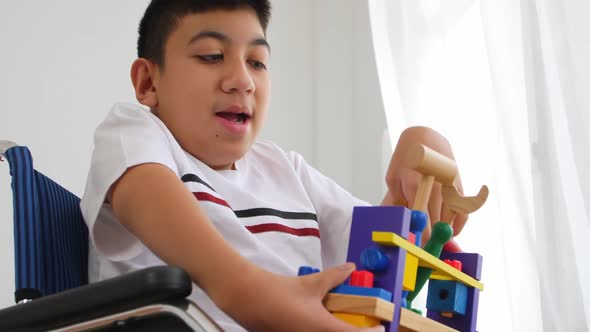 Disabled boy playing toy in a wheelchair.
