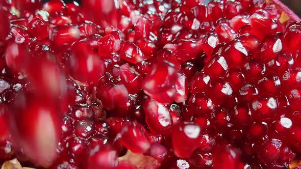 Super Closeup of Delicious Red Pomegranate Grains Falling in Slow Motion