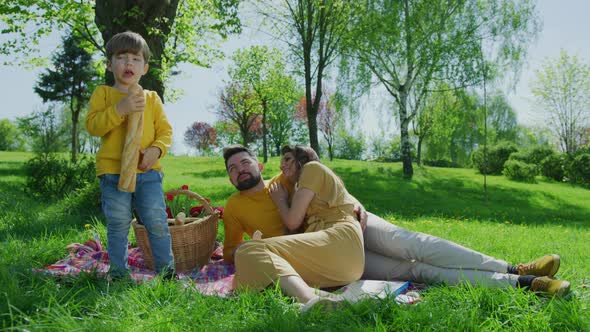 Boy eating a baguette on a picnic