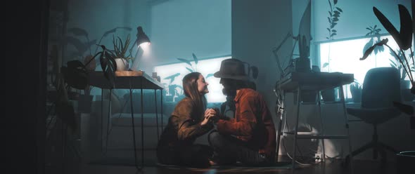 Couple kiss while sitting on the floor