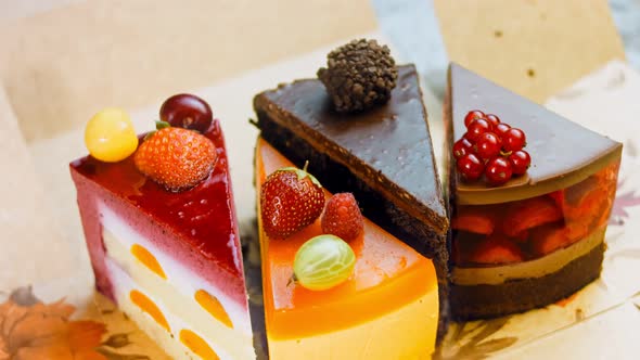 A Few Slices of White and Red Strawberry and Cherry Cake and Chocolate in an Open Box