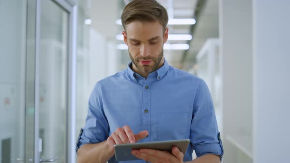 Joyful Businessman Using Tablet in Office