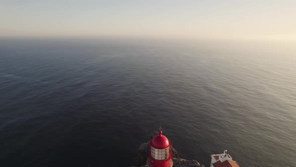 Reveal of Cabo de Sao Vicente lighthouse overlooking endless ocean waters,  Lagos, Algarve, Portugal