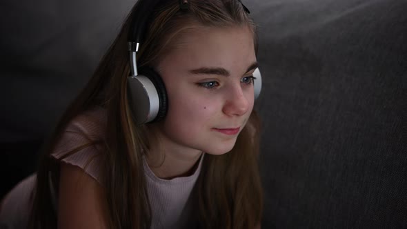 Caucasian Girl with Headphones Relaxing in Front of Her Computer