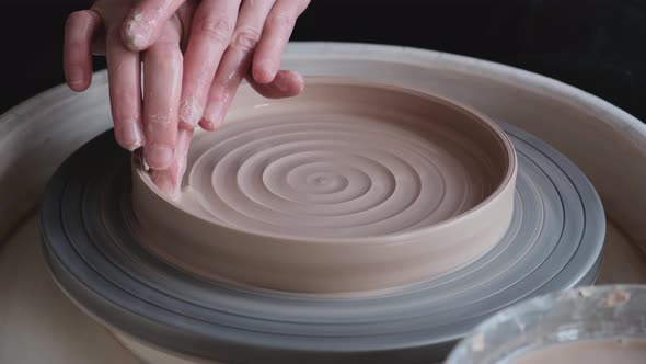 A woman works on a potter's wheel