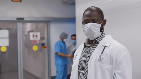 Portrait of African Young Ambulance Doctor with Stethoscope in Safety Mask and White Coat