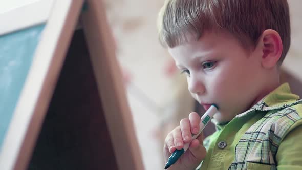 Little Boy in Green Shirt Holds Colorful Felt-tip Pen