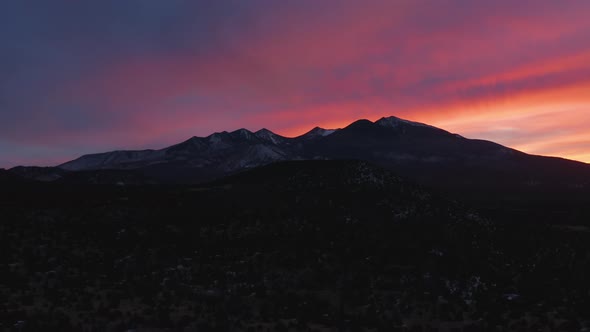 Red And Purple Sunset Sky Over Northern Arizona Mountain Range - Aerial Dolly Out