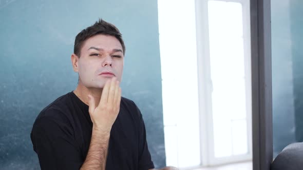 Closeup of a Man Applying Makeup and Powdering His Face