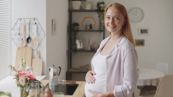 Smiling Pregnant Woman Posing for Camera at Home