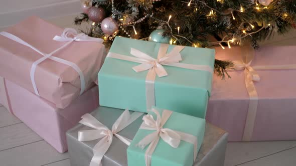 Christmas Gifts in Boxes of Blue and Pink Lie Next the Decorated Christmas Tree at Home