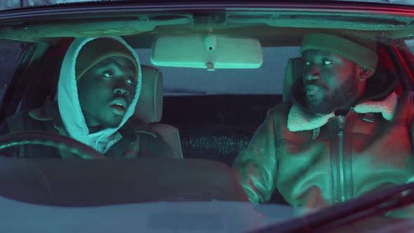 Two Black Men Chatting in Car in Evening
