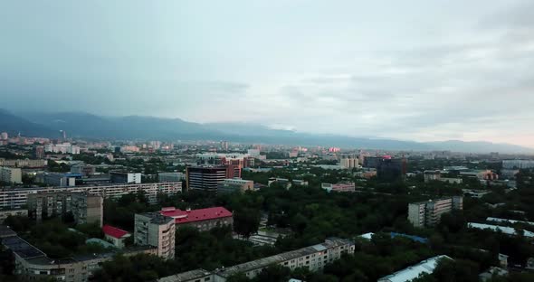 Clouds Over Mountains and City of Almaty at Sunset