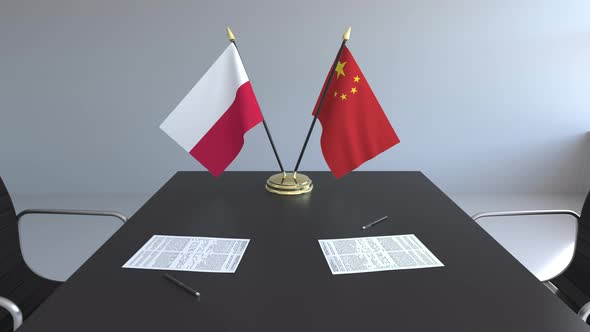 Flags of Poland and China and Papers on the Table alt