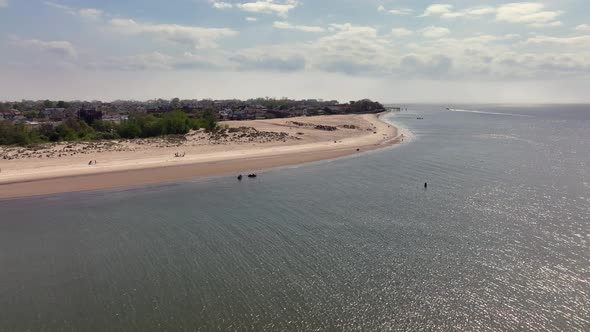 An aerial view of the beach on Gravesend Bay Brooklyn, NY on a beautiful day with blue skies and whi