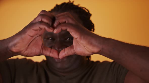 African Man Making Heart Shape with His Hands, Close Up.