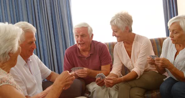 Group of senior friends playing cards