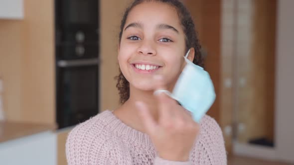 Smiling African American Gen z Teen Girl Taking Off Protective Face Mask