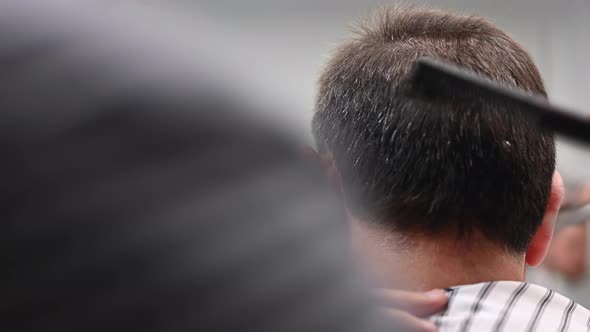 Barber Trimming Hair of Old Man at Barber Shop