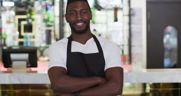 Portrait of african american barista smiling to camera wearing apron in cafe