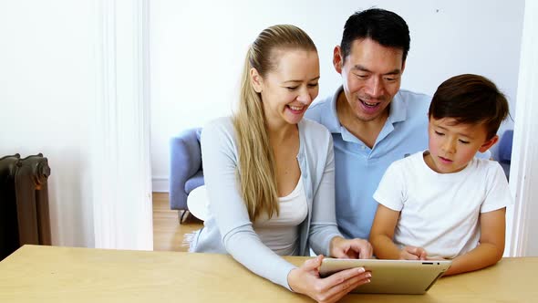 Happy family using digital tablet in living room