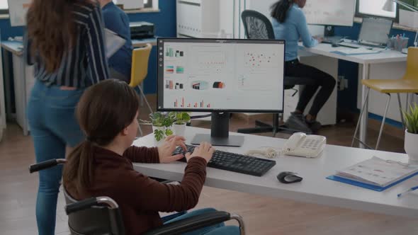 Handicapped Businesswoman Analysing Financial Statistics Sitting in Wheelchair