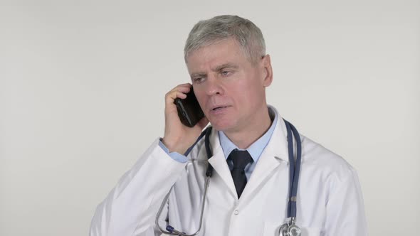 Senior Doctor Talking on Smartphone on White Background