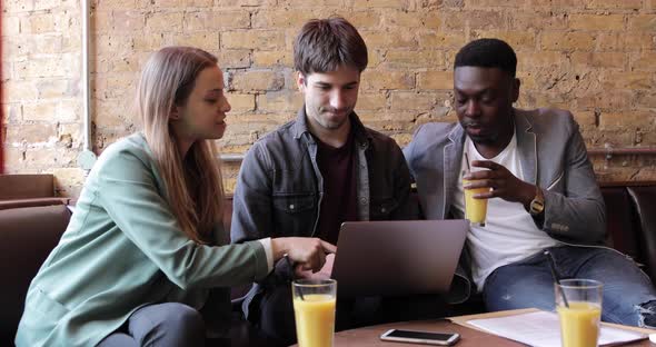 Happy friends working together with a laptop on a break