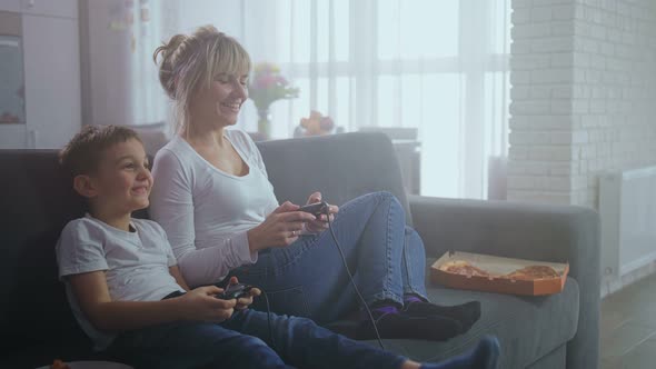 Joyful Mother and Son Playing Video Game at Home