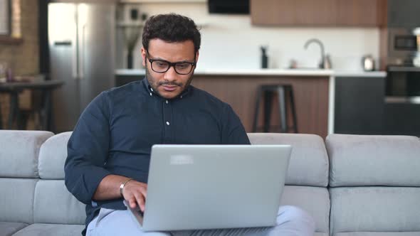 Multiethnic Hindu Freelancer Guy Using Laptop Computer at Home