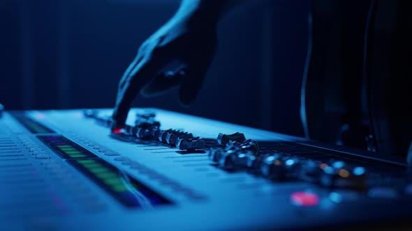 A Man Adjusts the Sound Using a Controller During a Performance