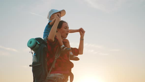 Mother with Little Boy Hiking Adventure with Child on Family Trip. A Woman with a Backpack Is