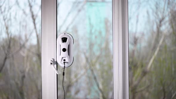 The Automatic Robot Assistant Washes the Glass of the Window