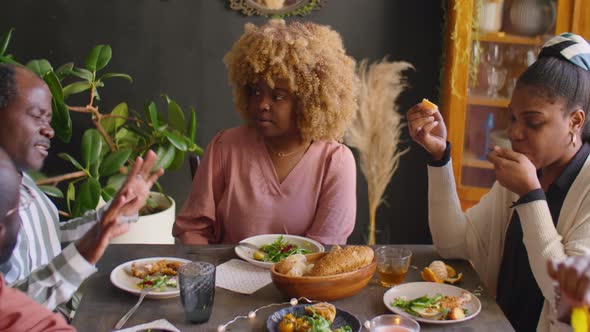 Young Woman Talking with Friends and Family at Holiday Dinner