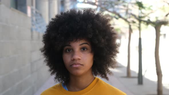 portrait of one young beautiful African or American woman looking at the camera  seriously