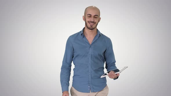 Arab Presenter Walking with Digital Tablet Swiping Pages on It on Gradient Background.