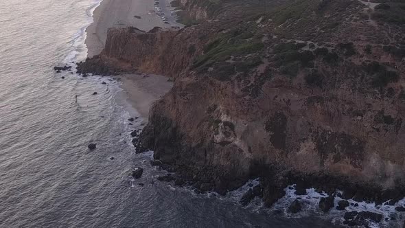 AERIAL: Flight Over Malibu, California View of Beach Shore Line Pacific Ocean at Sunset with