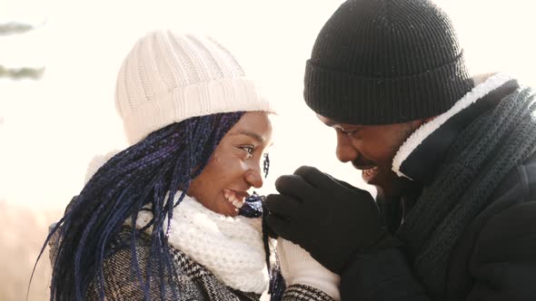 African American Couple Hugging in the Snowy Forest