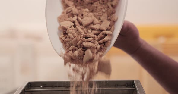 Crushed Wafer Biscuits Being Poured Into Food Machine. close up