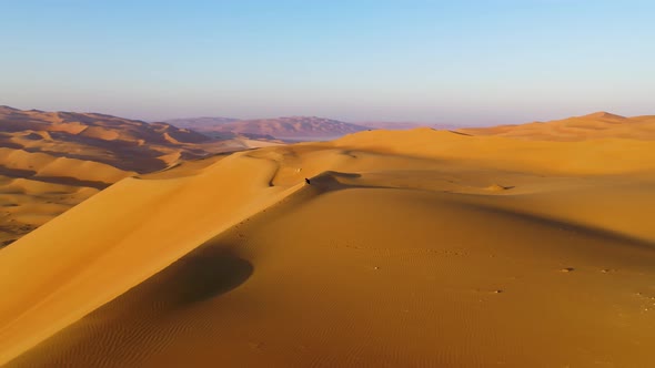 Aerial view of a man sitting on the edge of dunes, U.A.E.