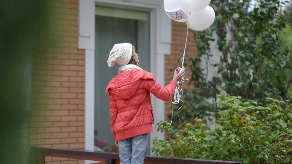 Back View Teenage Caucasian Girl on Autumn Spring Day Outdoors with White Balloons