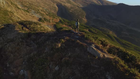 Aerial View of Hiker Man with Backpack on Top of a Mountain