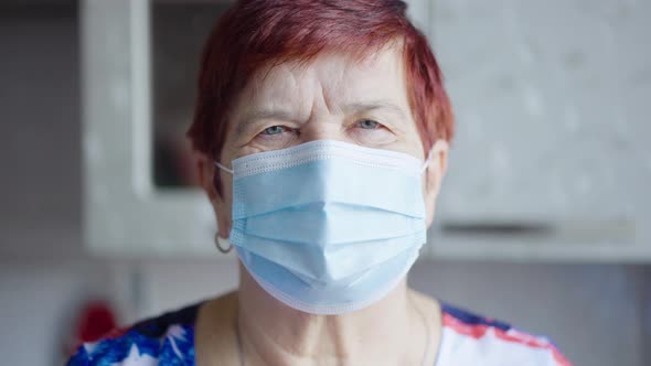 Senior woman in medical mask looking at camera