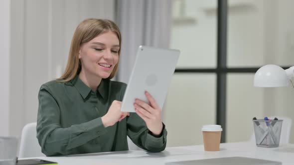 Video Chat on Tablet By Young Woman at Work 