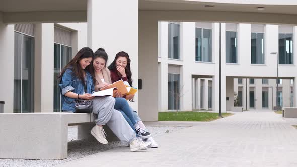 three asian girl students talking at break time sitting on campus