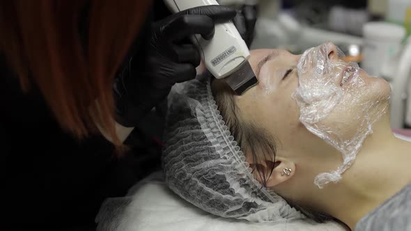 Cosmetologist Make Ultrasonic Face Cleaning on Woman Face in Beauty Clinic Salon